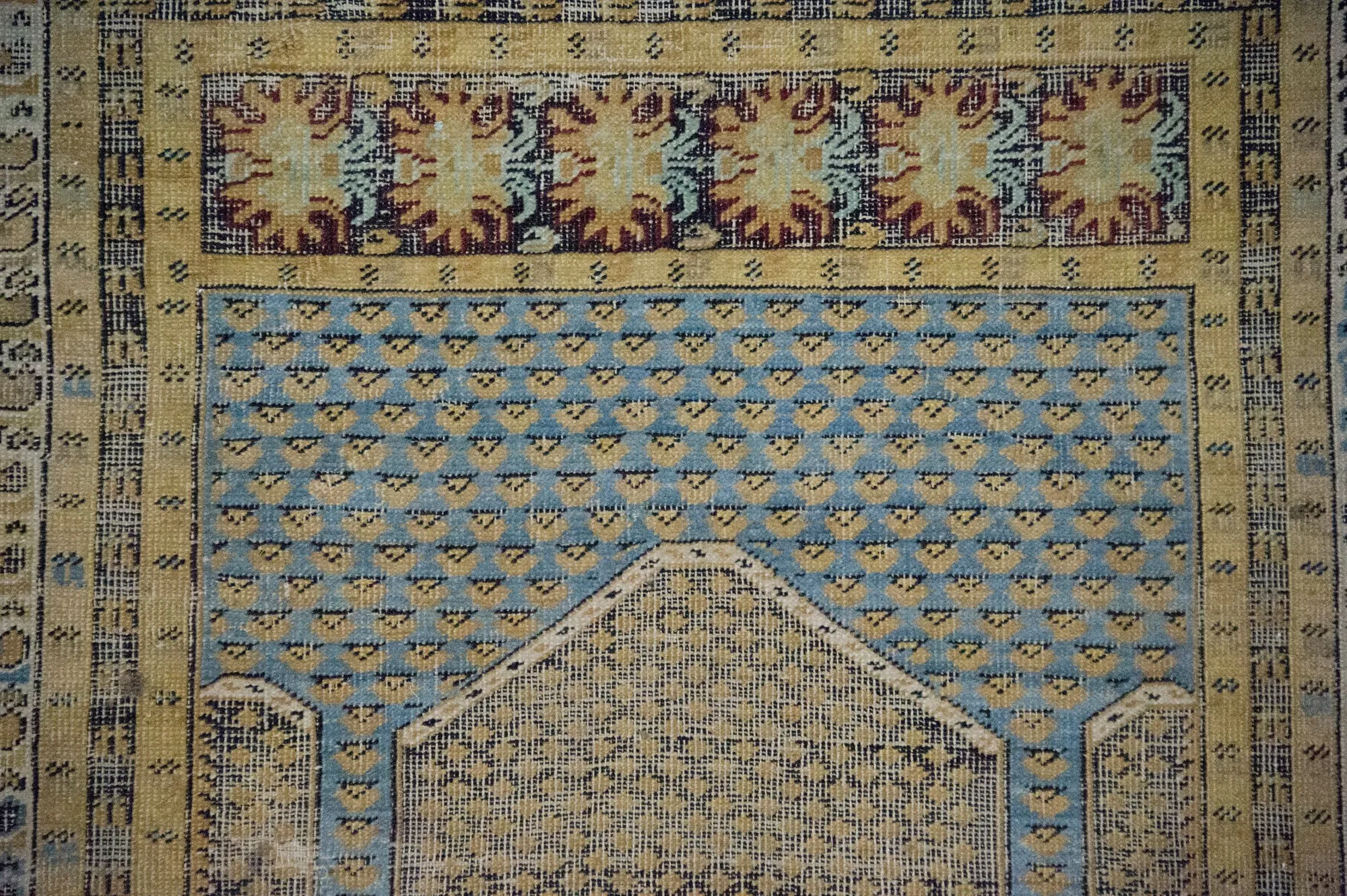 Un tapis de prière ancien, motif de mihrab, bleu et or.