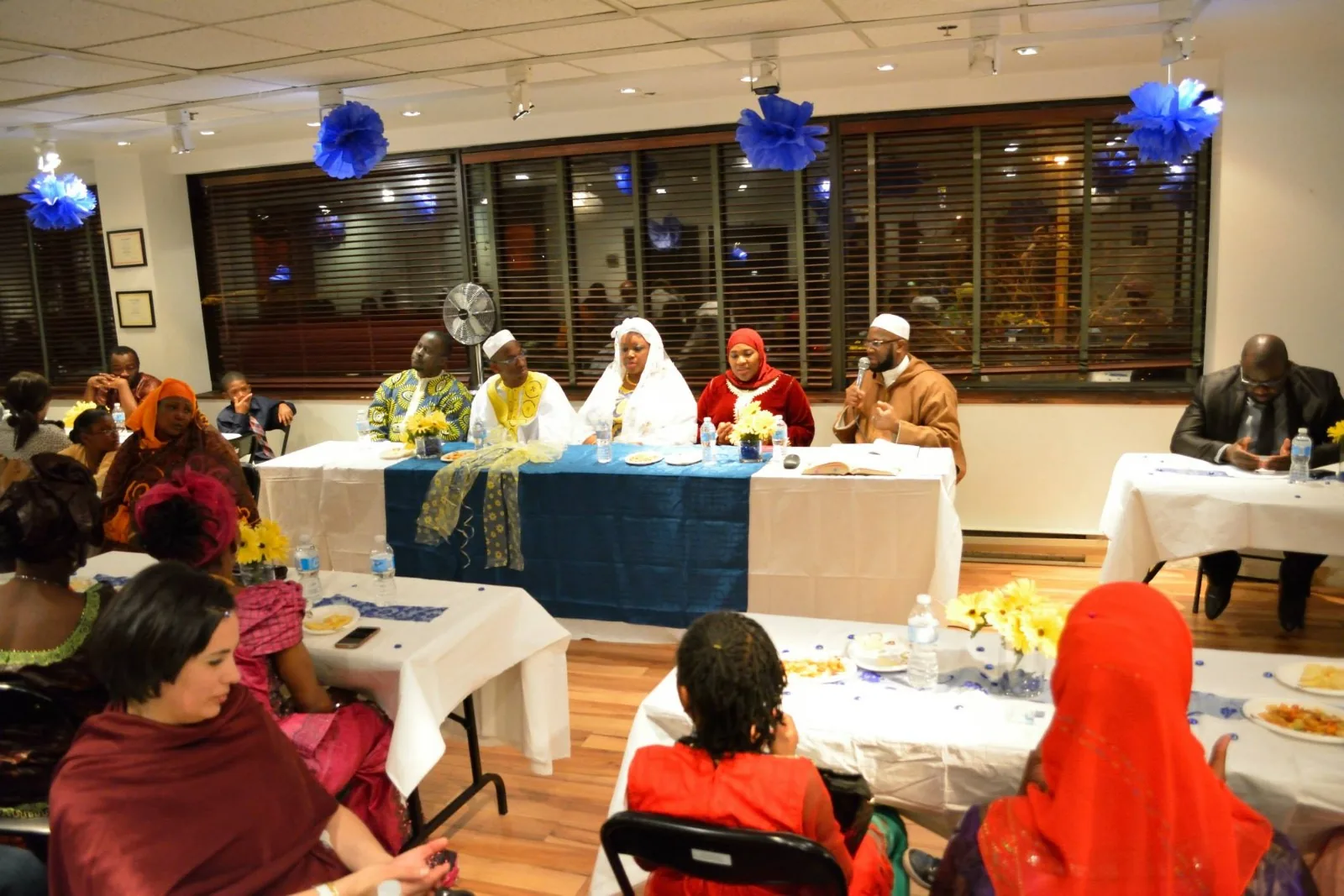 Members of the centre gathered in the hall, standing and talking.