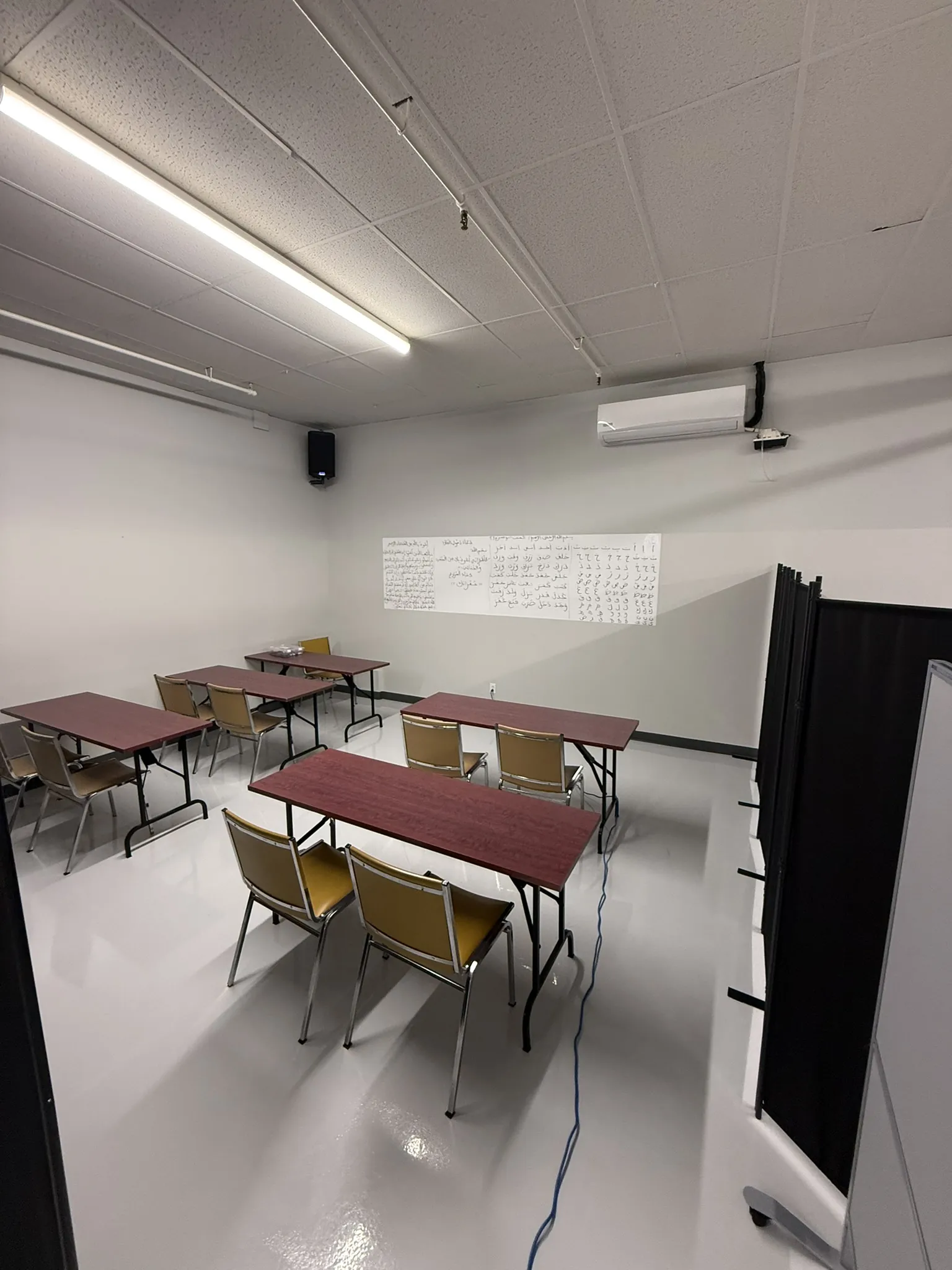 An empty classroom, tables and chairs in place.