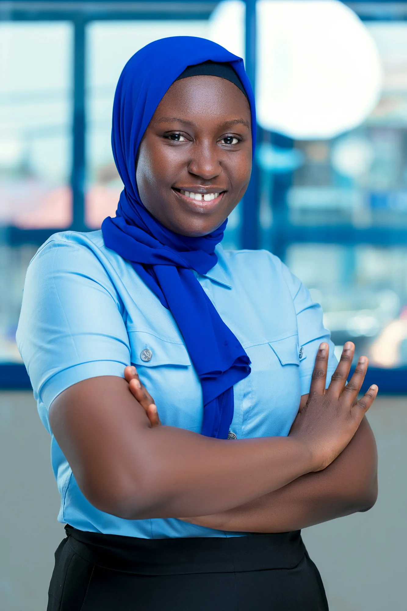 Le portrait d’une jeune femme en hijab bleu.